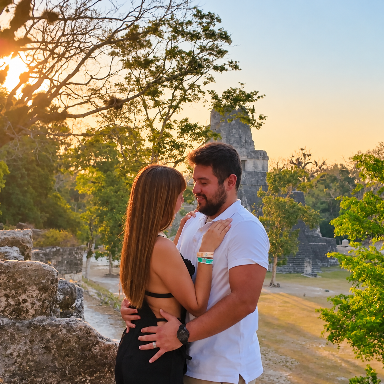 Alan y Lore abrazados al atardecer entre ruinas antiguas